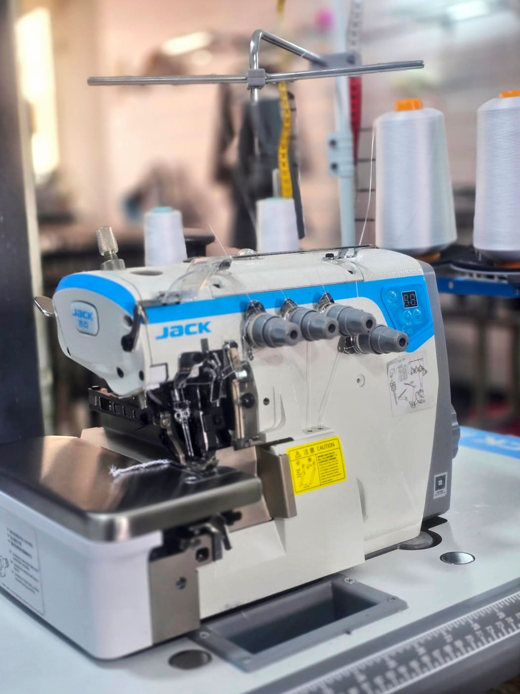 Overlock machine and thread cones used for seam and edge repairs at Younes Tailor
